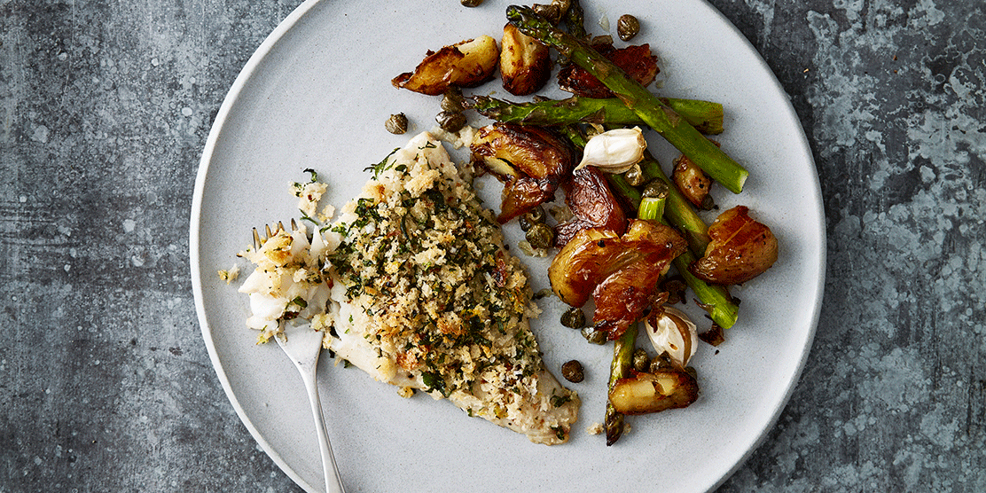 Herb crusted Norwegian haddock tray bake with crispy potatoes and asparagus