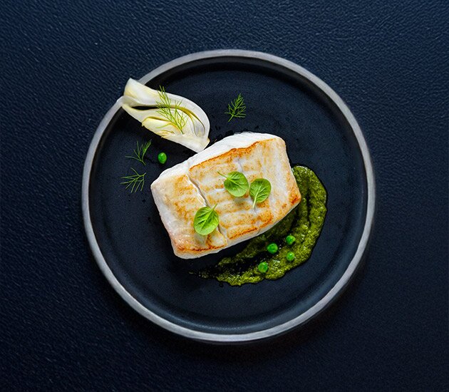 Pan fried Norwegian halibut with baked fennel, fresh peas and haricot verts sauté and chimichurri